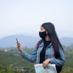 asian-woman-tourist-wearing-face-mask-looking-phone_1150-45013
